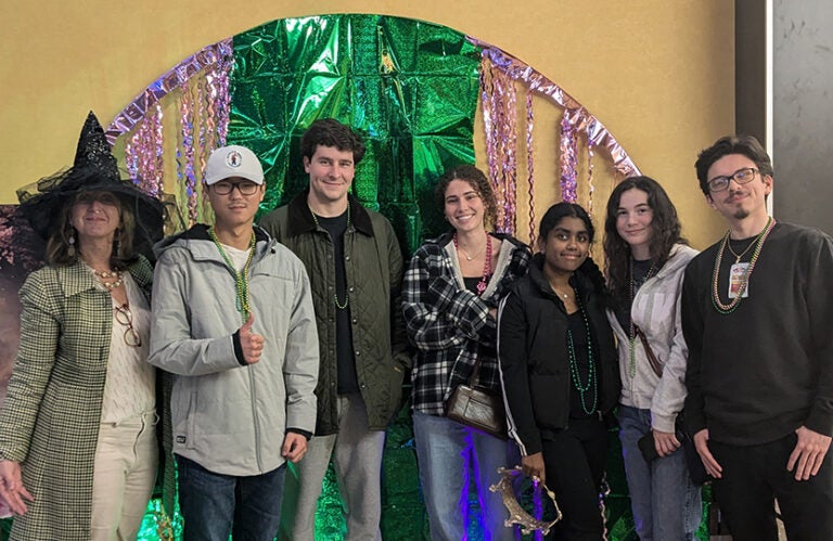 A faculty member in a witches hat and six East Carolina University students attend the musical "Wicked."