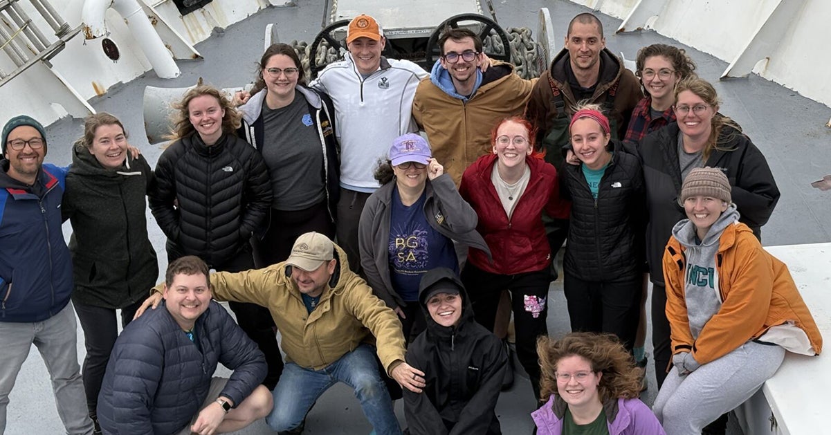A group of people on a ship wearing winter clothes