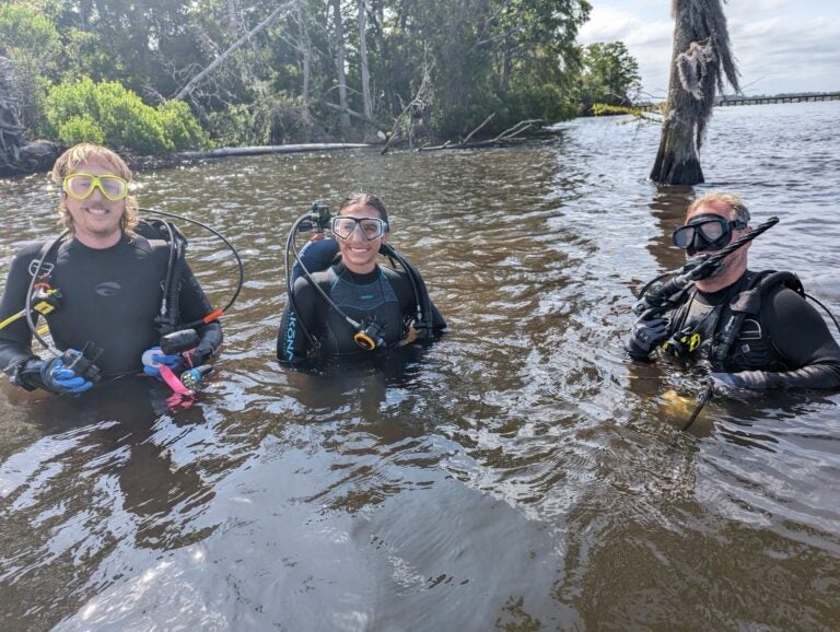 Maritime Studies student Olivia Livingston, center, with Dr. Jason Raupp, right, and another scuba diver performing research in the water