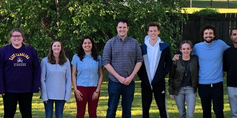 Hudson, center, with undergraduate and graduate students from his lab pose outside.