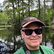 Dr. Jeff McKinnon with a river and trees in the background